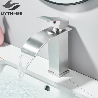 Modern brushed stainless steel single hole basin faucet with sleek angular waterfall design and red indicator dot