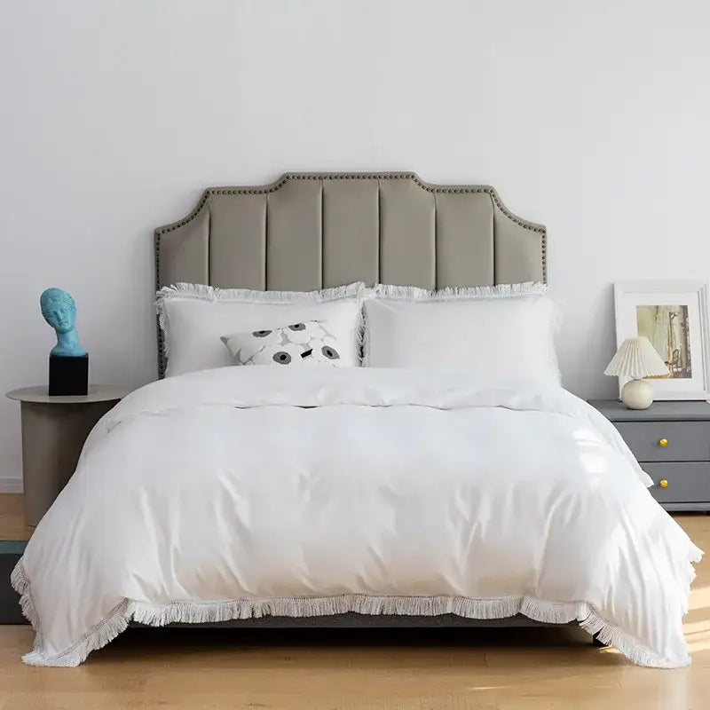 White duvet with fringed edges and matching pillows on gray upholstered bedhead in decorbites brushed hotel style bedding sets
