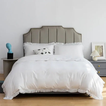 White duvet with fringed edges and matching pillows on gray upholstered bedhead in decorbites brushed hotel style bedding sets