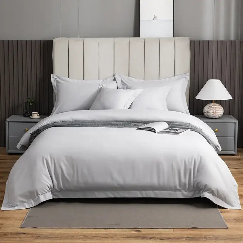 A plush light gray brushed hotel style bedding set with satin finish and subtle vertical pleats on the headboard
