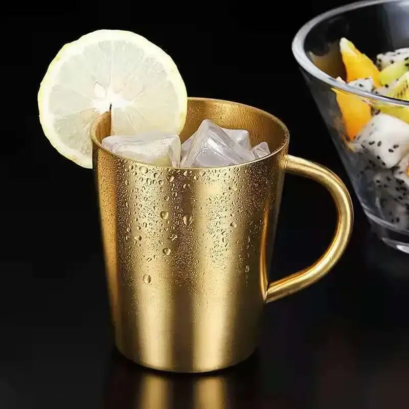 Golden stainless steel thermal mug with a brushed finish and rounded handle in a kitchen drinkware set