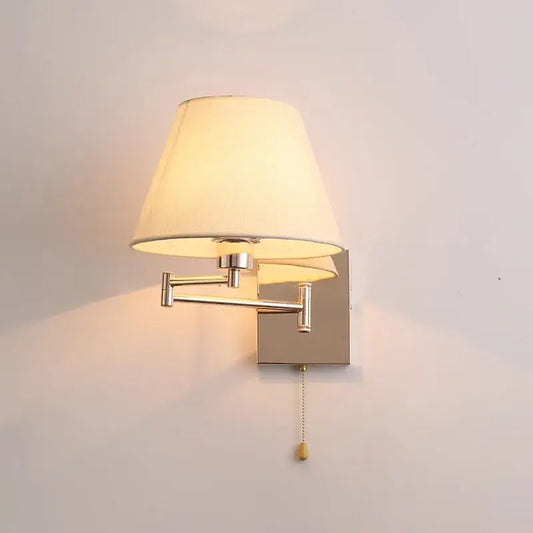 Adjustable rocker arm wall lamp with brushed nickel metal arms and cream fabric shade for bedroom lighting