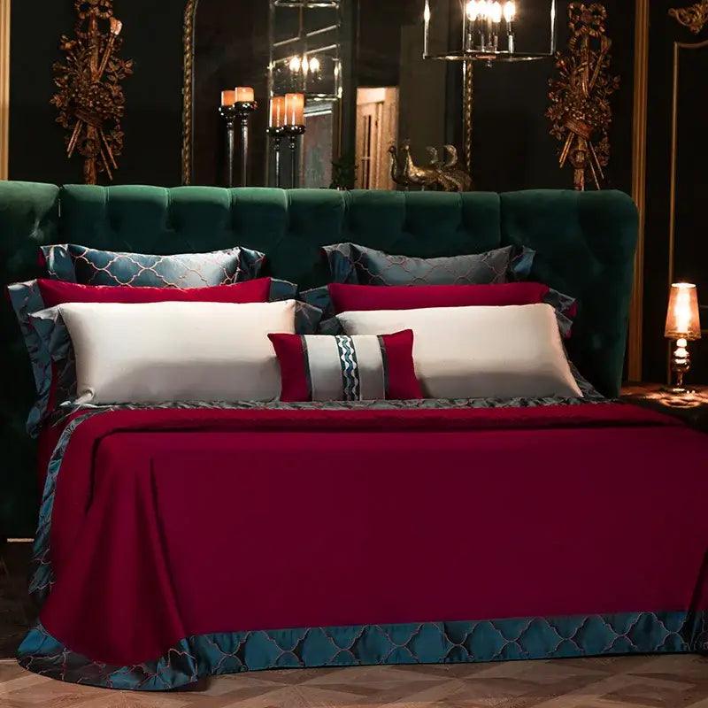 Emerald green tufted velvet headboard with gold accents and mirrored wall in bedroom featuring burgundy 200s egyptian cotton embroidery bedding set