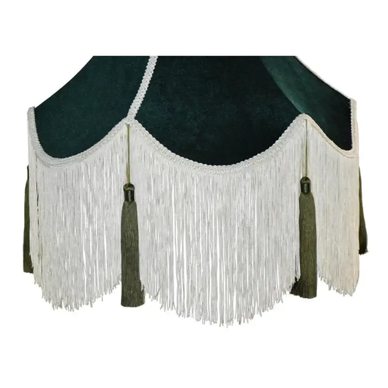 Dark green velvet lampshade with white fringe and matching tassels complementing burgundy wine red velvet decor