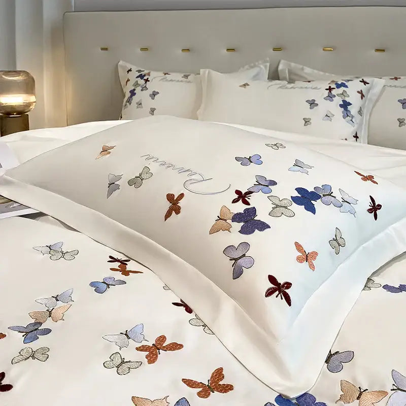 White satin pillowcase with decorbites butterfly embroidery in blue purple orange and gray on cotton bedding set