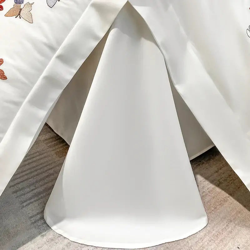White satin skirt with delicate decorbites butterfly embroidery along the hem complementing butterfly embroidery cotton bedding set decor