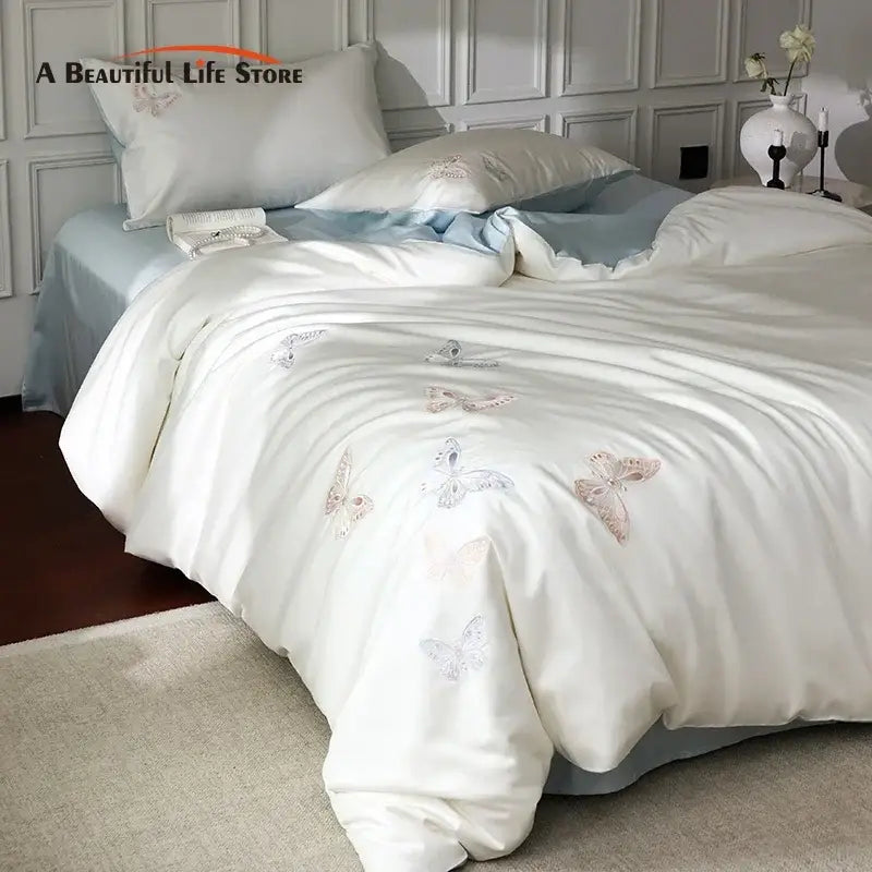 White satin duvet cover with decorbites butterfly embroidery in soft pastels made from lyocell cotton bedding set