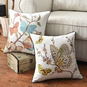 White cotton pillow cover with embroidered butterfly floral design in blue orange green and brown for bedroom decor