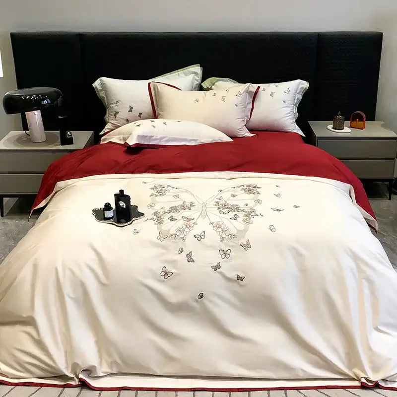 Cream satin bedding set featuring intricate butterfly flowers embroidery in gray and pink with a bold red border