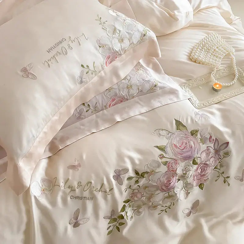 Cream-colored satin bedding set with butterfly flowers embroidery in soft pink and silver for elegant bedroom decorbites decor