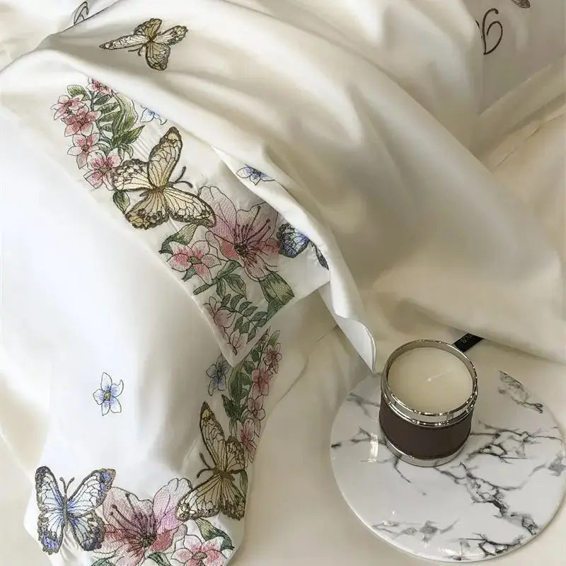 White satin pillowcase with delicate butterfly flowers embroidery in pastel hues from decorbites bedding set