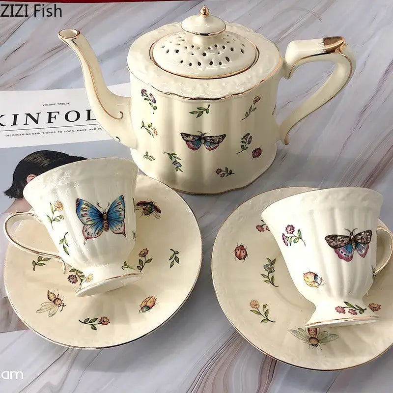 Cream-colored butterfly gold ceramic teapot set with gold trim and hand-painted butterfly gold floral designs