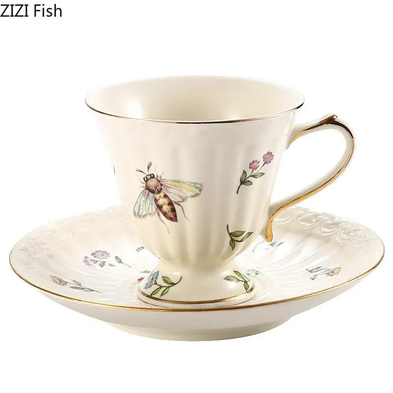 Cream-colored butterfly gold ceramic cup and ornate saucer with gold trim and delicate bee illustration porcelain tea set