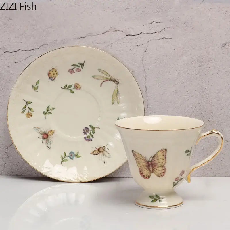 Cream-colored butterfly gold ceramic cup with gold trim and matching saucer featuring insects and flowers porcelain tea set