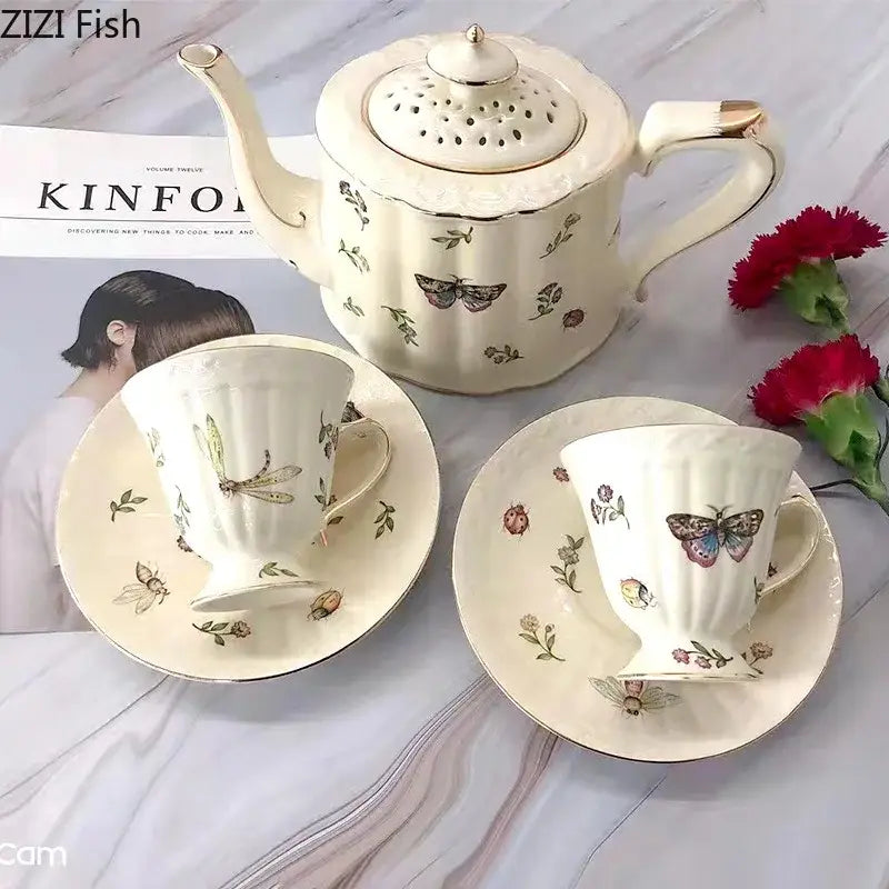 Cream-colored porcelain teapot with gold-trimmed lid and handle featuring butterfly gold ceramic motifs