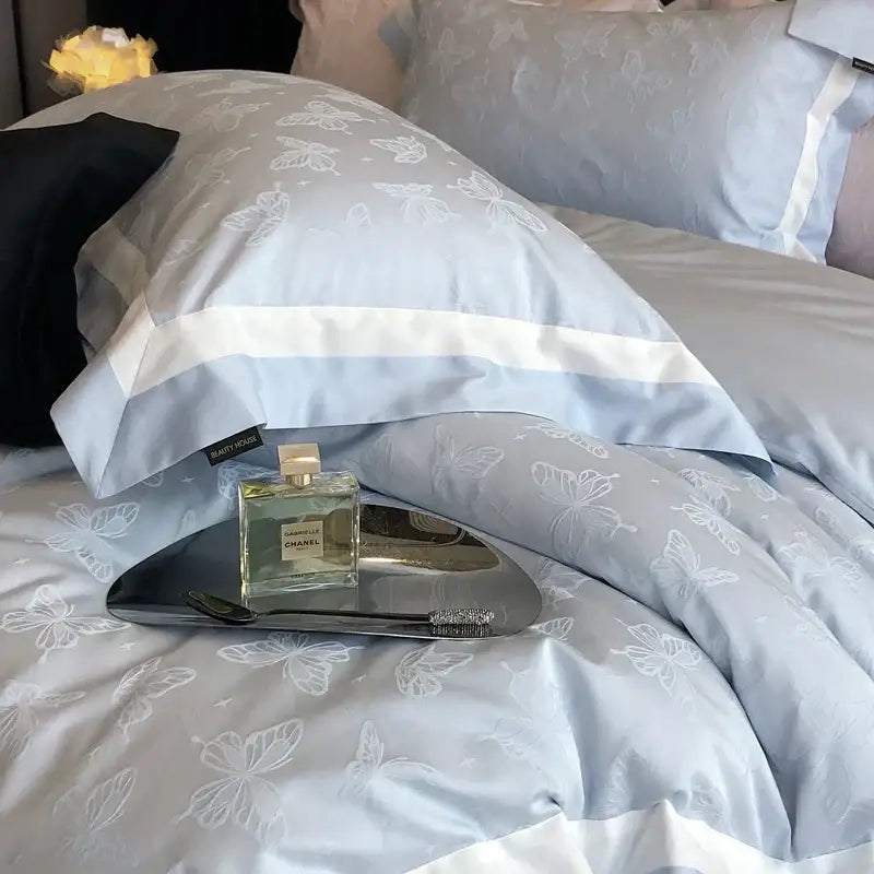Light blue satin pillowcase with delicate white butterfly embroidery and wide white stripe in decorbites butterfly jacquard bedding set