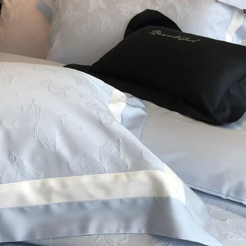 Light blue satin pillowcase with subtle butterfly jacquard embroidery and wide cream border in decorbites bedding set