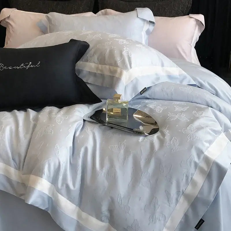 Light blue satin duvet cover with white butterfly jacquard embroidery and cream piping in decorbites butterfly jacquard bedding set