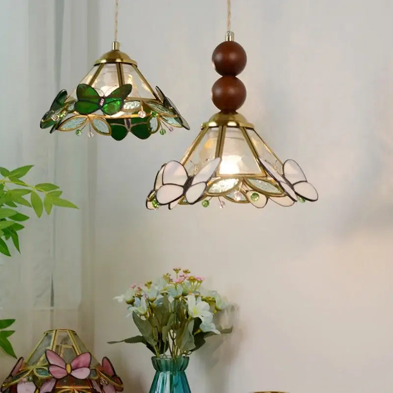 Two decorbites butterfly tiffany glass pendant lights with green and white butterfly motifs in brass fixtures