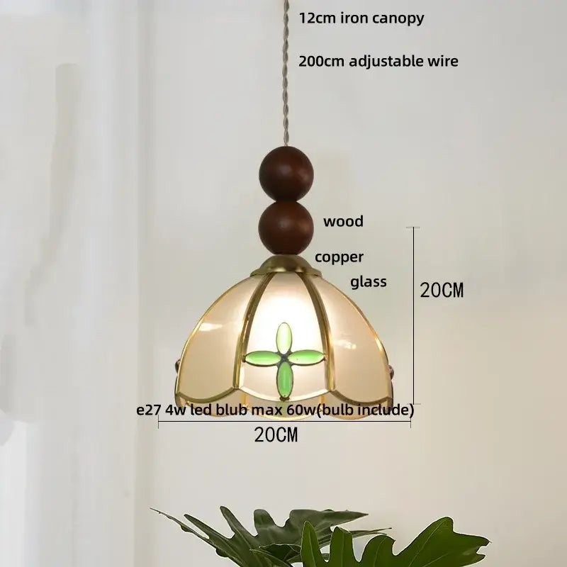 A 20cm tall decorbites butterfly tiffany glass pendant lamp with warm blue and green floral shade supported by copper and wood