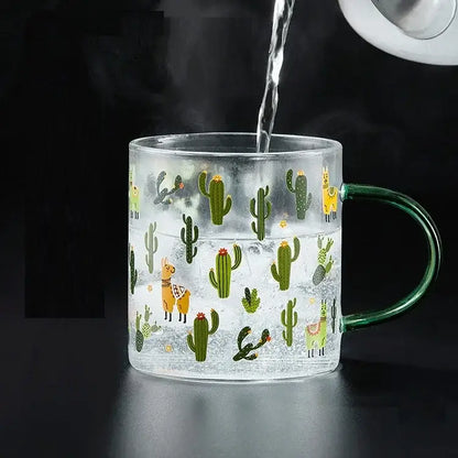 Clear glass tea milk cup with green handle featuring green cacti and yellow llamas decorbites cactus glass design