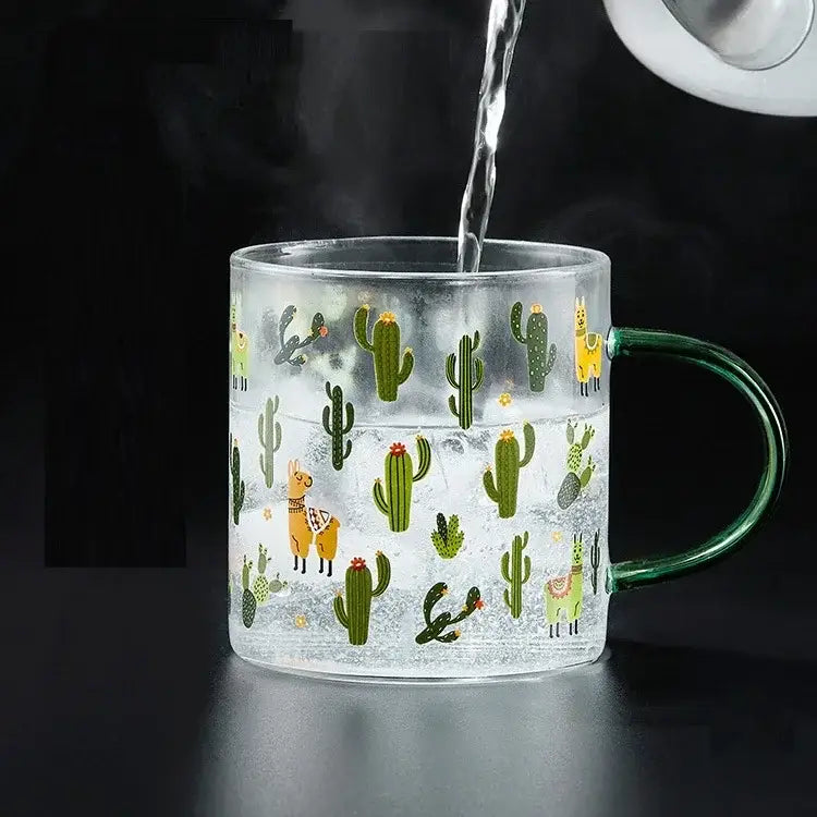Clear glass tea milk cup with green handle featuring green cacti and yellow llamas decorbites cactus glass design
