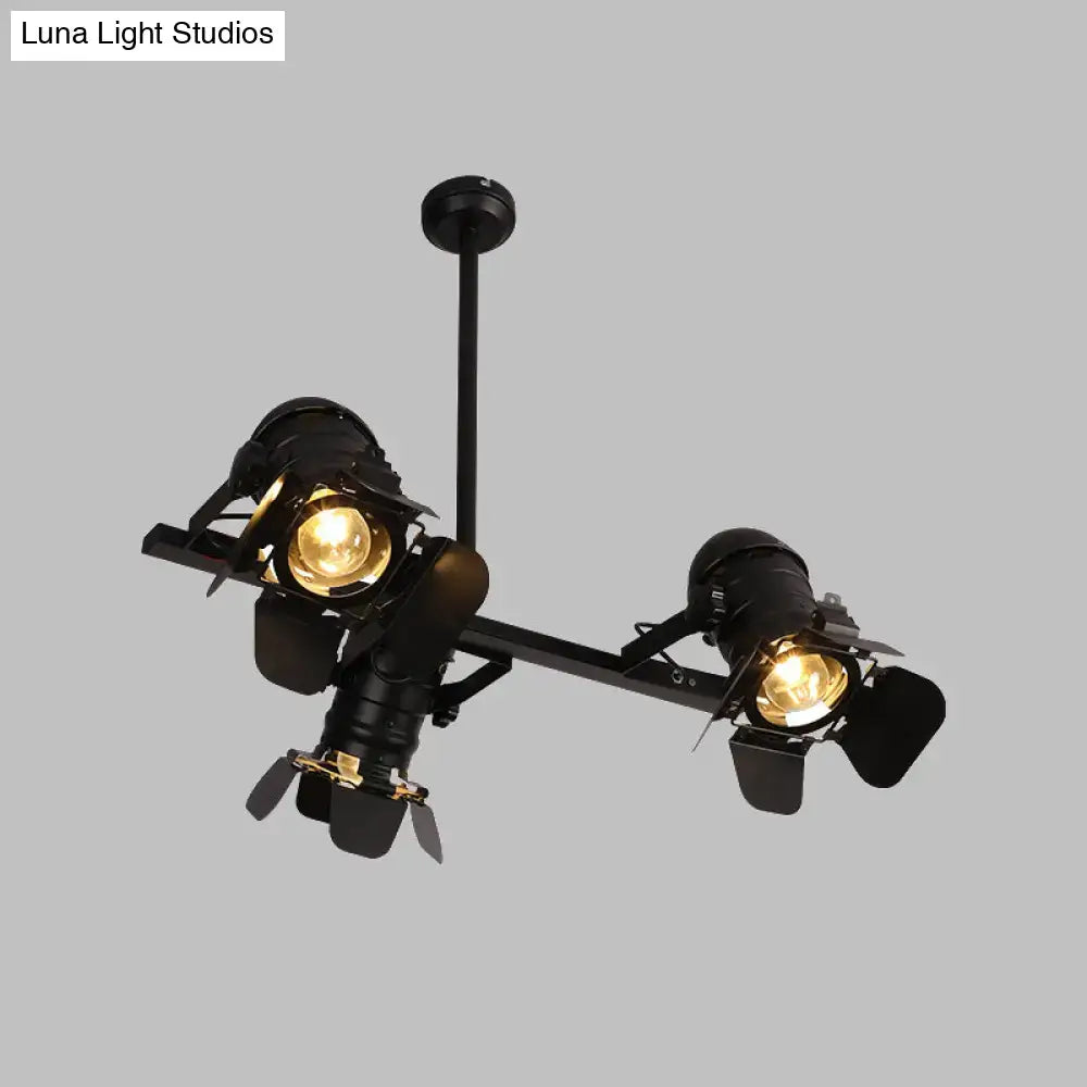 Industrial-style metallic island lighting fixture with art deco black finish and two vintage projector lights emitting warm glow