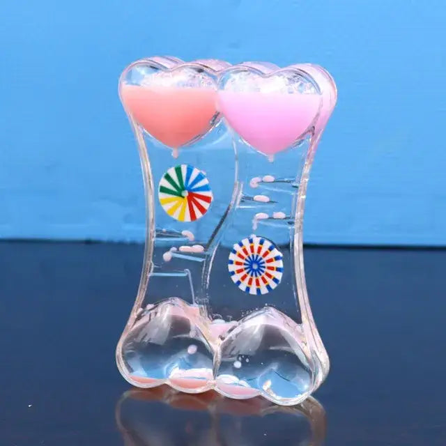 Clear glass liquid motion sand timer with pink heart compartments and blue green decorative patterns for living room decor