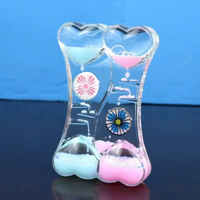 Clear heart-shaped liquid motion sand timer with blue and pink sand compartments for living room decor