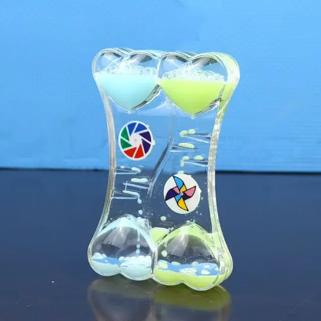 Clear glass liquid motion sand timer with heart-shaped chambers in blue and green and colorful circular decals for living room decor