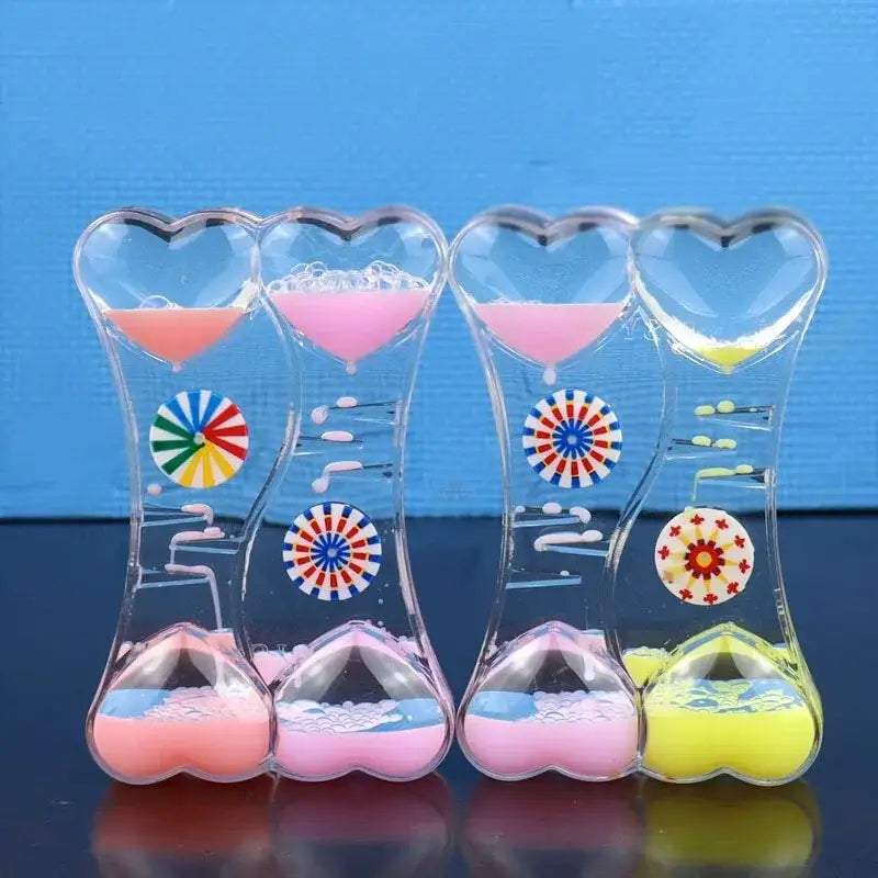 Four heart-shaped liquid motion sand timers with colorful swirling liquids and decorative patterns in plastic bodies