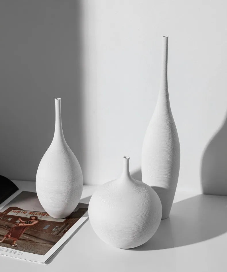 Three minimalist white ceramic vases with subtle texture and slender necks from capiron zen collection for home decor