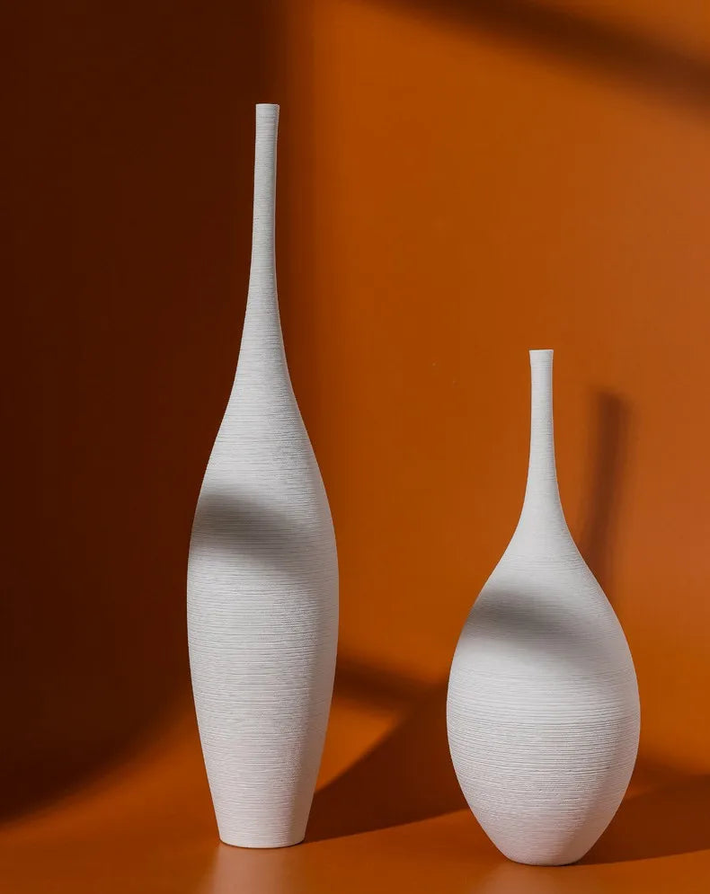 Two elegant white ceramic capiron zen vases with textured ribbed surface and slender necks for home decoration