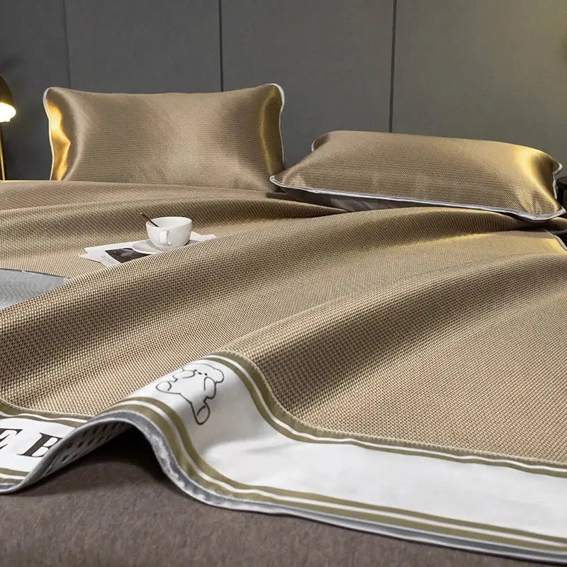 Gold-colored textured cooling bed sheet with white border and embroidered bear design in decorbites carbon light cooling set