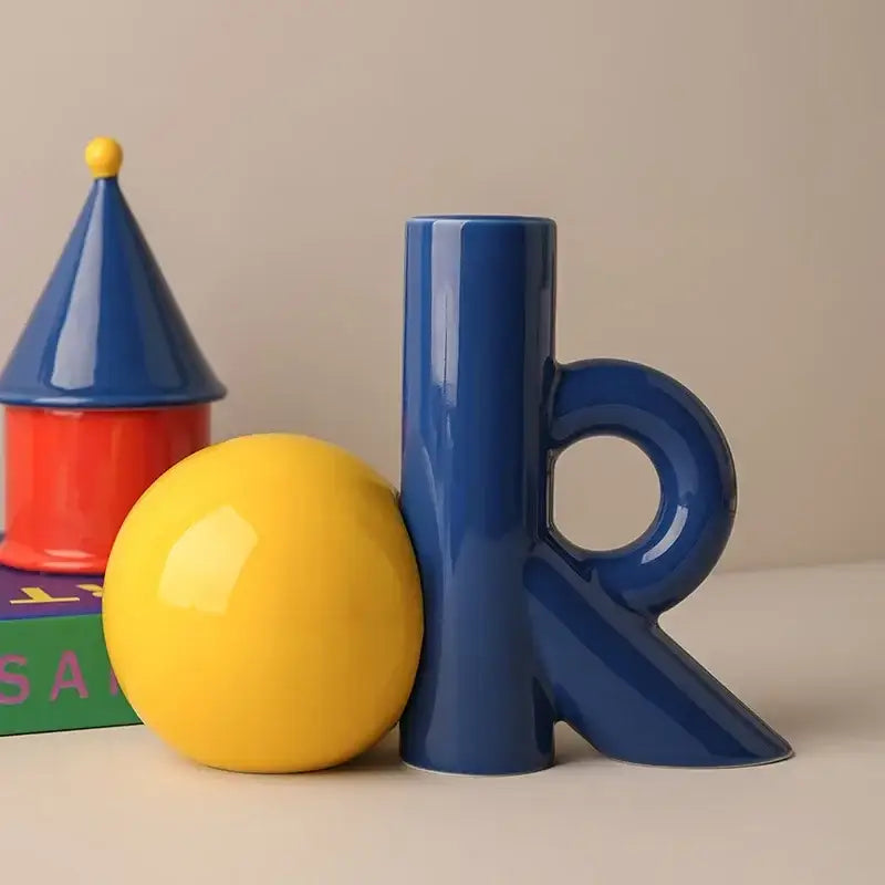 Glossy blue abstract ceramic vase shaped like letter r with circular handle and angular base for decorbites cartoon abstract decor
