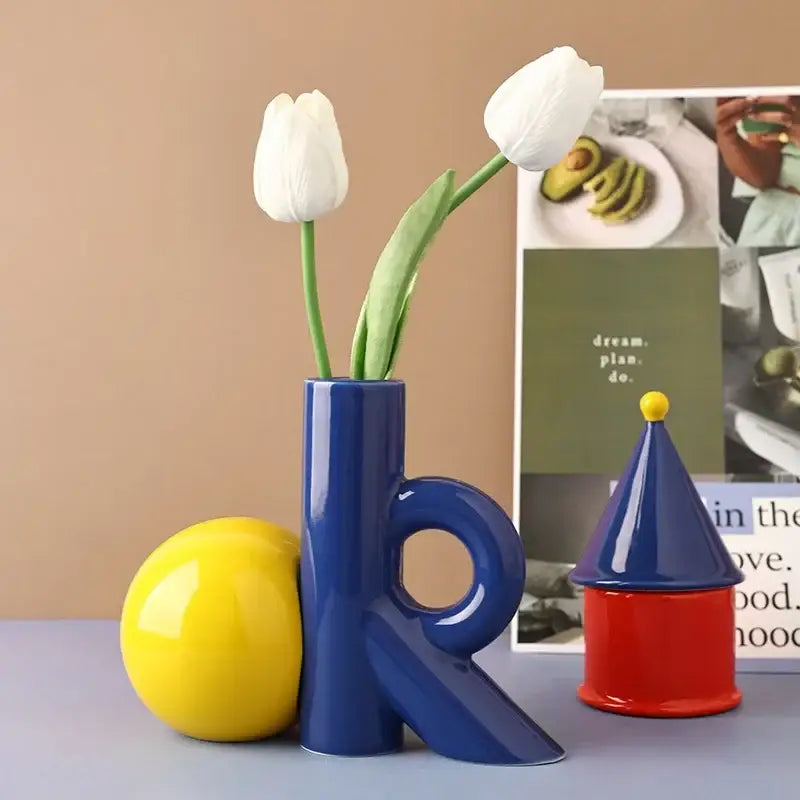 Blue abstract ceramic vase shaped like letter k holding white tulips for decorbites cartoon abstract living room decor