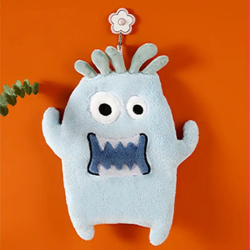 Light blue coral velvet cartoon animal hand towel shaped like a plush monster with stitched eyes and zigzag mouth