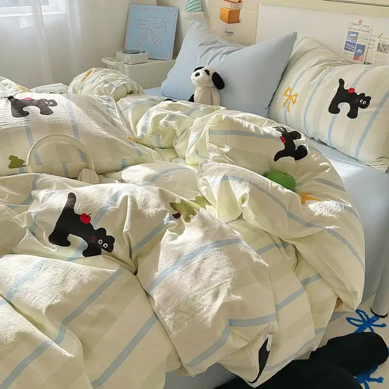 Cream satin quilt cover set with cream color, light blue stripes, and black cat appliqués holding red apples