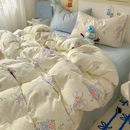 Cream-colored satin quilt cover set with cream quilt cover featuring floral and ribbon patterns in pink, lavender, and blue