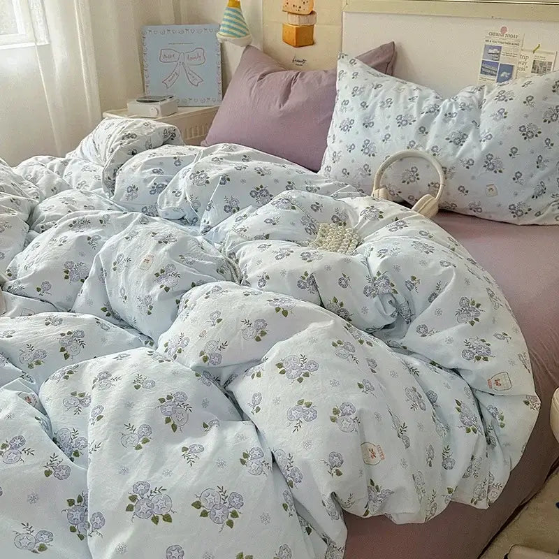 Light blue floral-patterned cream satin quilt cover set with soft quilted texture and pastel accents for bedroom bedding