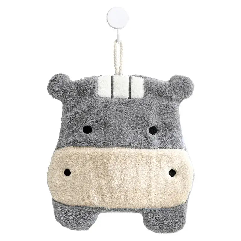 Gray and cream plush hippo hand towel with black embroidered eyes and white striped headband hanging on hook decorbites cartoon animals coral