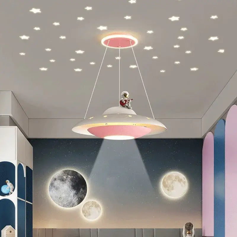 Whimsical decorbites cartoon astronaut pendant light in pink and white with astronaut figurine playing guitar on top