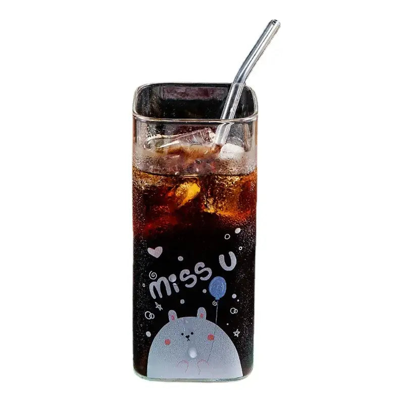A clear glass coffee mug with a gray cartoon rabbit design miss u text filled with dark soda and ice