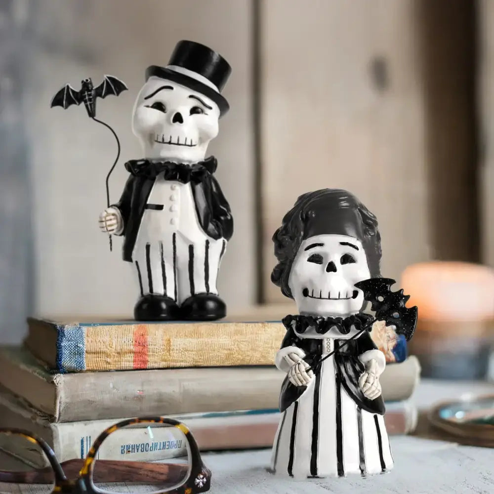 Black and white skeleton gentleman bat figurine dressed in formal attire holding a bat for living room decor