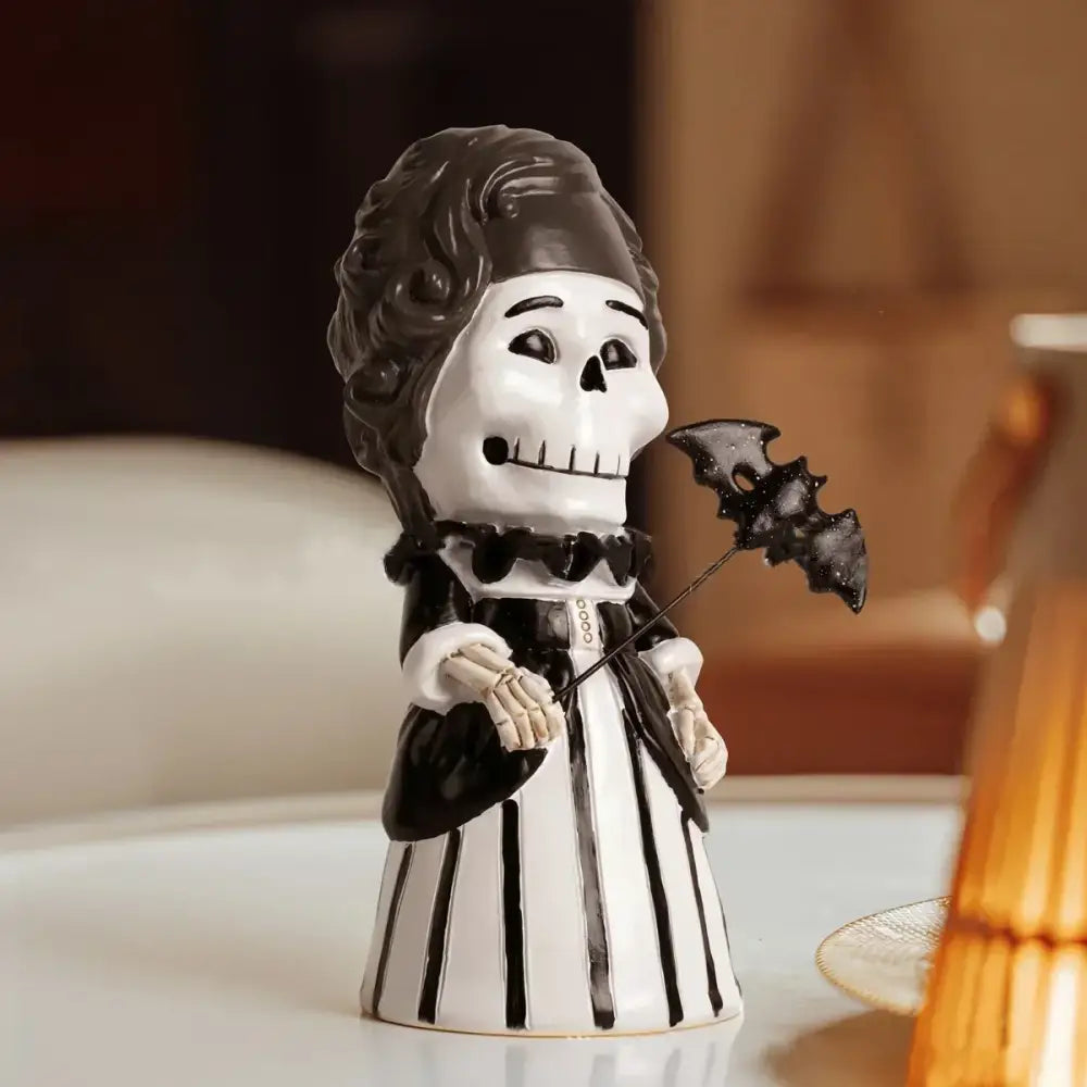 A black and white ceramic skeleton gentleman bat figurine dressed in an 18th-century gown for living room decor
