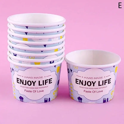 A stack of light purple decorbites cartoon paper cups with playful pattern and enjoy life print for dessert use