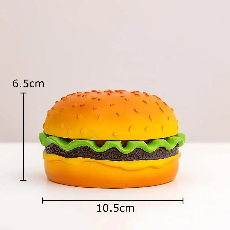 A vibrant yellow and green resin cartoon burger ashtray shaped like a miniature hamburger for office table decor