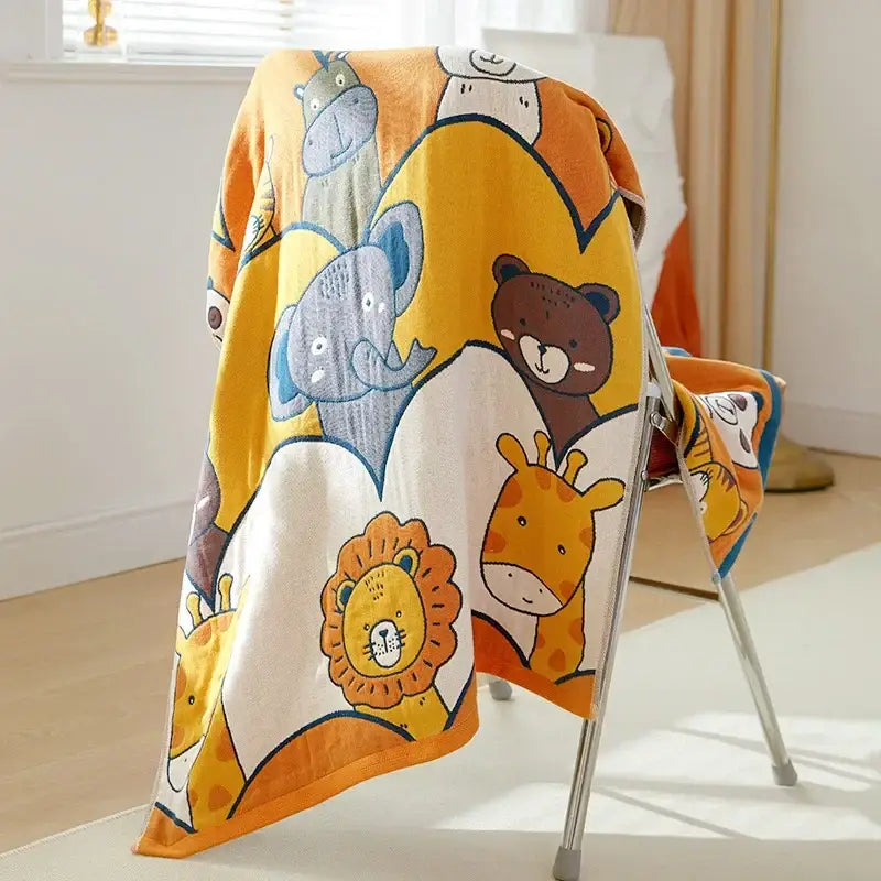 A soft yellow and white cotton gauze bath towel with cartoon animals including elephant and lion for bathroom use