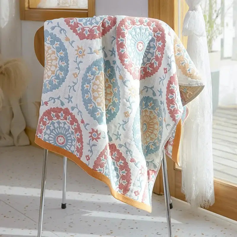 A soft white cotton gauze bath towel with pink blue beige mandala and orange trim from decorbites for bathroom use