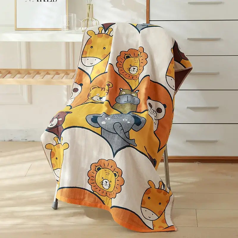 A cream-colored decorbites cotton gauze bath towel with cartoon animals for nursery and bedroom use